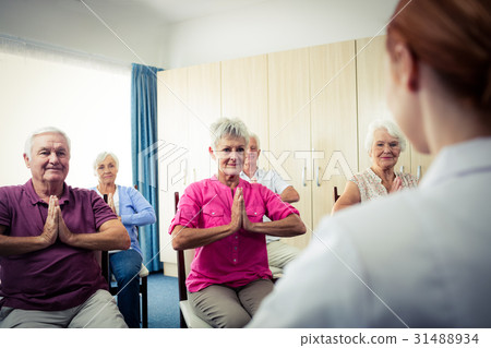 Group of seniors doing exercises with nurse Group of seniors doing exercises with nurse 31488934