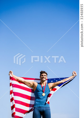Athlete posing with american flag and gold medals around his neck Athlete posing with american flag and gold medals around his neck 31488935