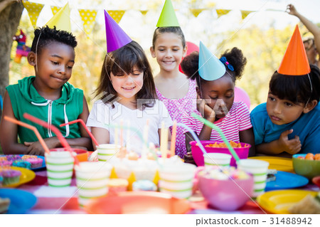 Cute children looking candles during a birthday party Cute children looking candles during a birthday party 31488942