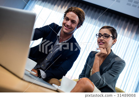 Low angle view of business associate looking a laptop 31489008