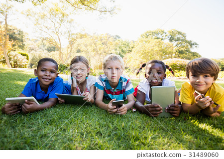 Kids using technology during a sunny day Kids using technology during a sunny day 31489060