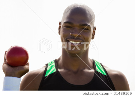 Male athlete holding shot put ball 31489169
