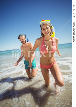 Couple running in water 31489193