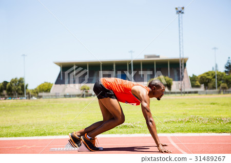 Athlete on a starting block about to run Athlete on a starting block about to run 31489267
