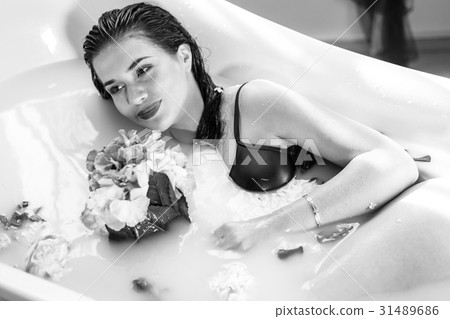 Sexy brunette woman relaxing in hot milk bath with Sexy brunette woman relaxing in hot milk bath with 31489686