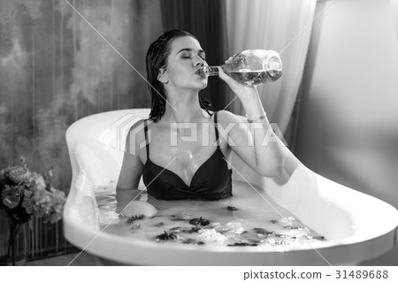 Sexy brunette woman drinking champagne while Sexy brunette woman drinking champagne while 31489688