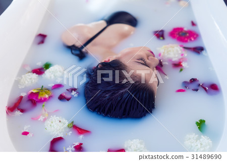 Sexy brunette woman relaxing in hot milk bath with Sexy brunette woman relaxing in hot milk bath with 31489690