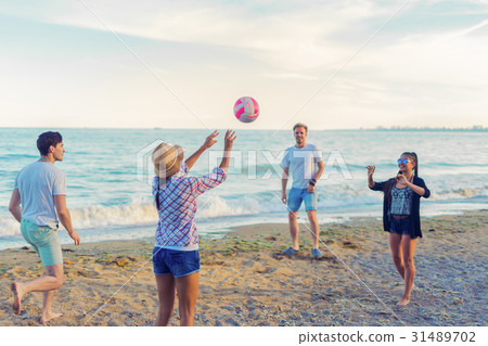 friends playing volleyball on a wild beach during friends playing volleyball on a wild beach during 31489702