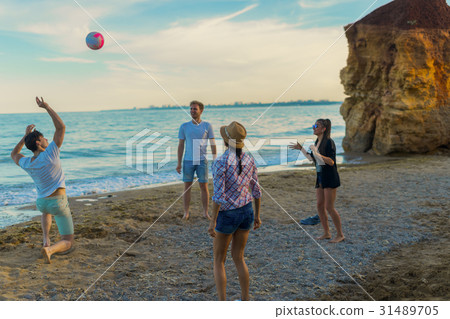 friends playing volleyball on a wild beach during friends playing volleyball on a wild beach during 31489705