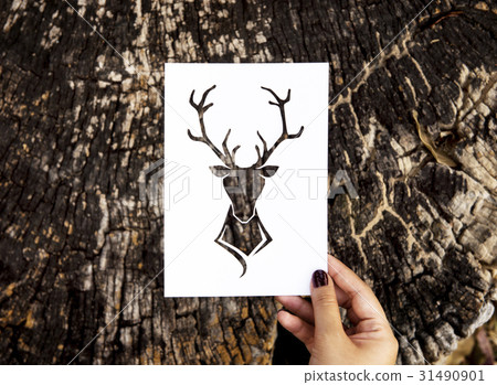 Human hand holding wild life moose perforated paper craft in nature Human hand holding wild life moose perforated paper craft in nature 31490901