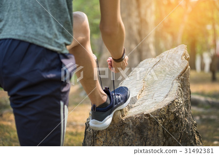 young man runner tightening running shoe laces, 31492381