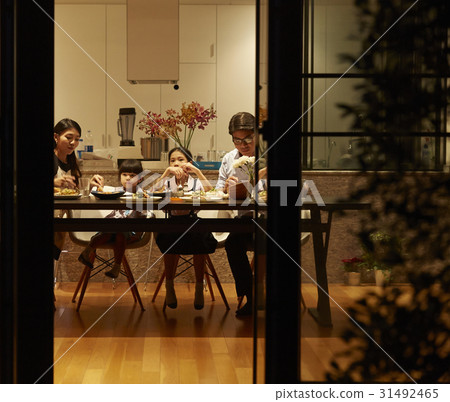 a family with two kids is having dinner at home a family with two kids is having dinner at home 31492465
