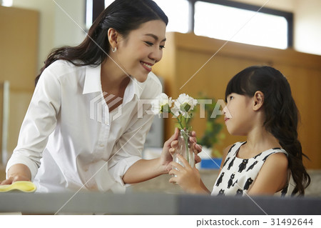 mom is happy when the kid holds the vase for her. 31492644