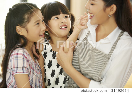 mom is happily playing with her daughters. 31492654