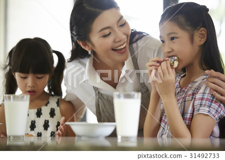 Mother is smiling at her daughters while having breakfast. 31492733