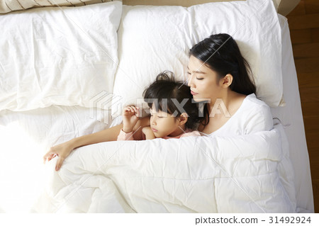 An Asian woman is hugging her daughter and sleeping together An Asian woman is hugging her daughter and sleeping together 31492924