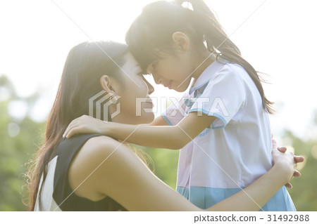 mother is hugging and forehead touching her daughter 31492988