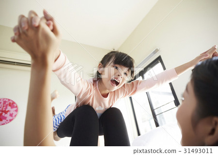 a baby girl is playing airplane game with her mother 31493011