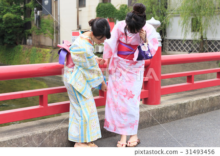 夏天圖像享用在一座紅色橋樑的欄杆的yukata樂趣的小姐 31493456