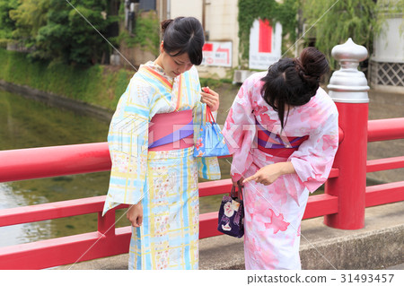 夏天圖像享用在一座紅色橋樑的欄杆的yukata樂趣的小姐 夏天圖像享用在一座紅色橋樑的欄杆的yukata樂趣的小姐 31493457