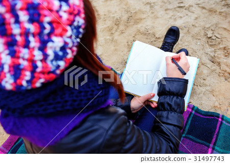 beautiful girl sitting on the beach  31497743