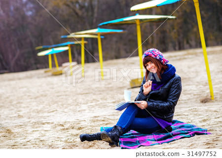 beautiful girl sitting on the beach  31497752