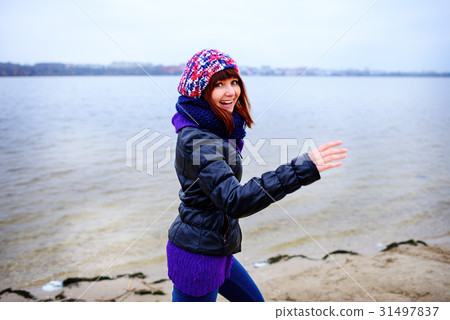 young Caucasian slim woman runs along beach autumn 31497837