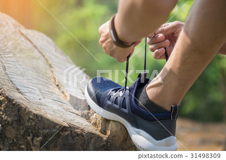 young man runner tightening running shoe laces, young man runner tightening running shoe laces, 31498309