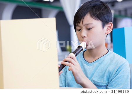 Elementary school student who blows recorder 31499189