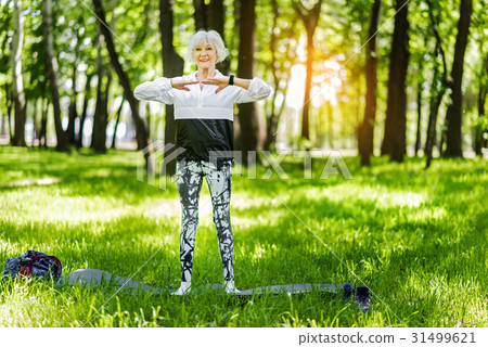 Happy elderly slim woman exercising outside Happy elderly slim woman exercising outside 31499621