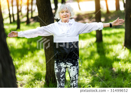 Happy old woman doing relaxation exercises in 31499652