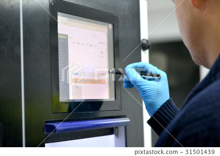 The man works on the machine monitor 31501439