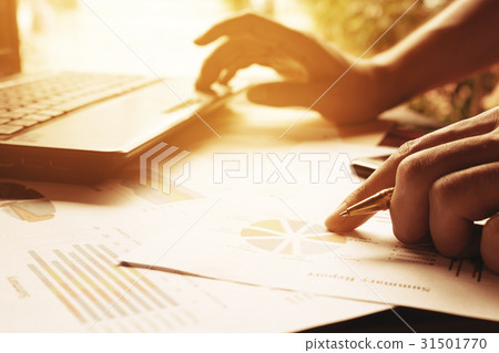 Businessman holding pen on charts and graph 31501770