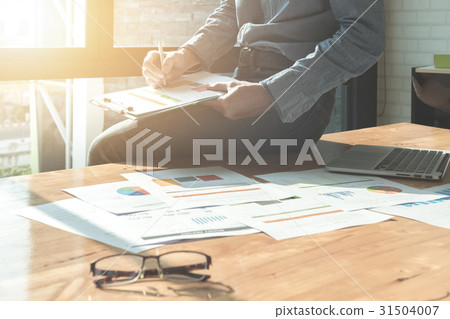 Businessman analyzing investment charts Businessman analyzing investment charts 31504007