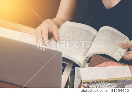 Close up of student hand reading a book at library 31504400