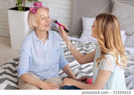 Young woman applying makeup to her mother 31504818