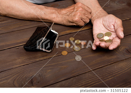 Man holds the coins over the old empty wallet Man holds the coins over the old empty wallet 31505122