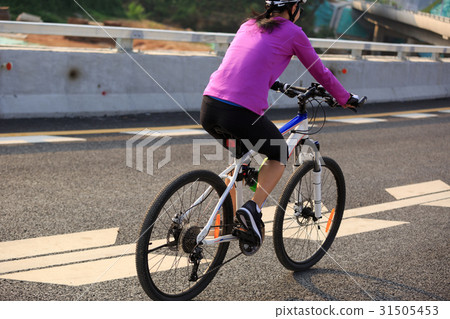 one woman cycling mountain bike on road 31505453
