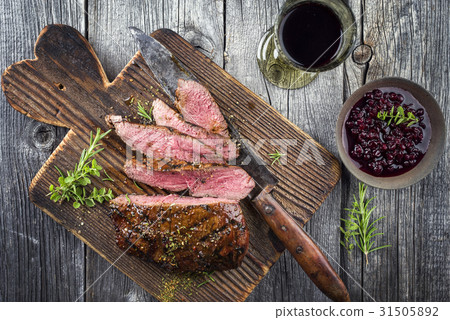 Vanison Steak on old Cutting Board 31505892