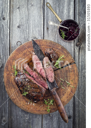 Vanison Steak on old Cutting Board 31505893