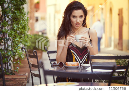 beautiful young girl drinking coffee in a old town cafe - outdoo beautiful young girl drinking coffee in a old town cafe - outdoo 31506766