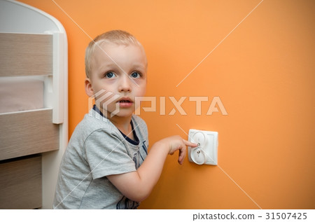 Child near to the electrical socket 31507425