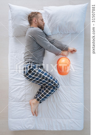 Serious professional engineer lying on the bed Serious professional engineer lying on the bed 31507881