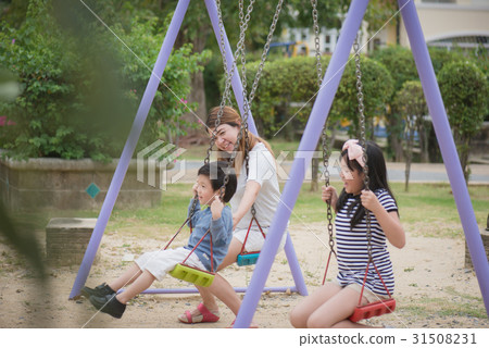 asian family swinging on the playground asian family swinging on the playground 31508231