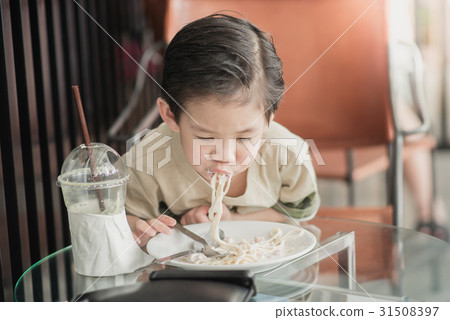 Cute Asian chid eating Spaghetti Carbonara 31508397