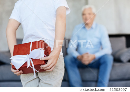 Loving adorable kid hiding a present for his Loving adorable kid hiding a present for his 31508997