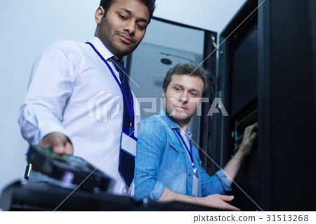 Nice positive engineers looking at the rack server Nice positive engineers looking at the rack server 31513268