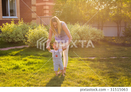 first steps of little boy in summer park 31515063