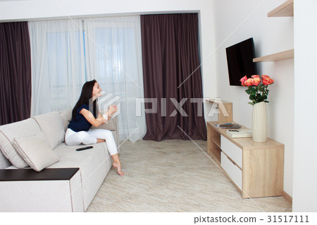 Woman watching tv at home and holding a remote 31517111