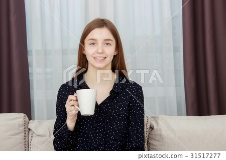 Portrait of beautiful young woman sitting on sofa 31517277
